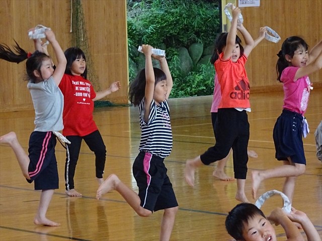 輪っかを持って踊る子ども